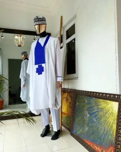 A white Agbada with royal blue embroidery detailing and royal blue Swarovski stone with hand woven Aboki hat