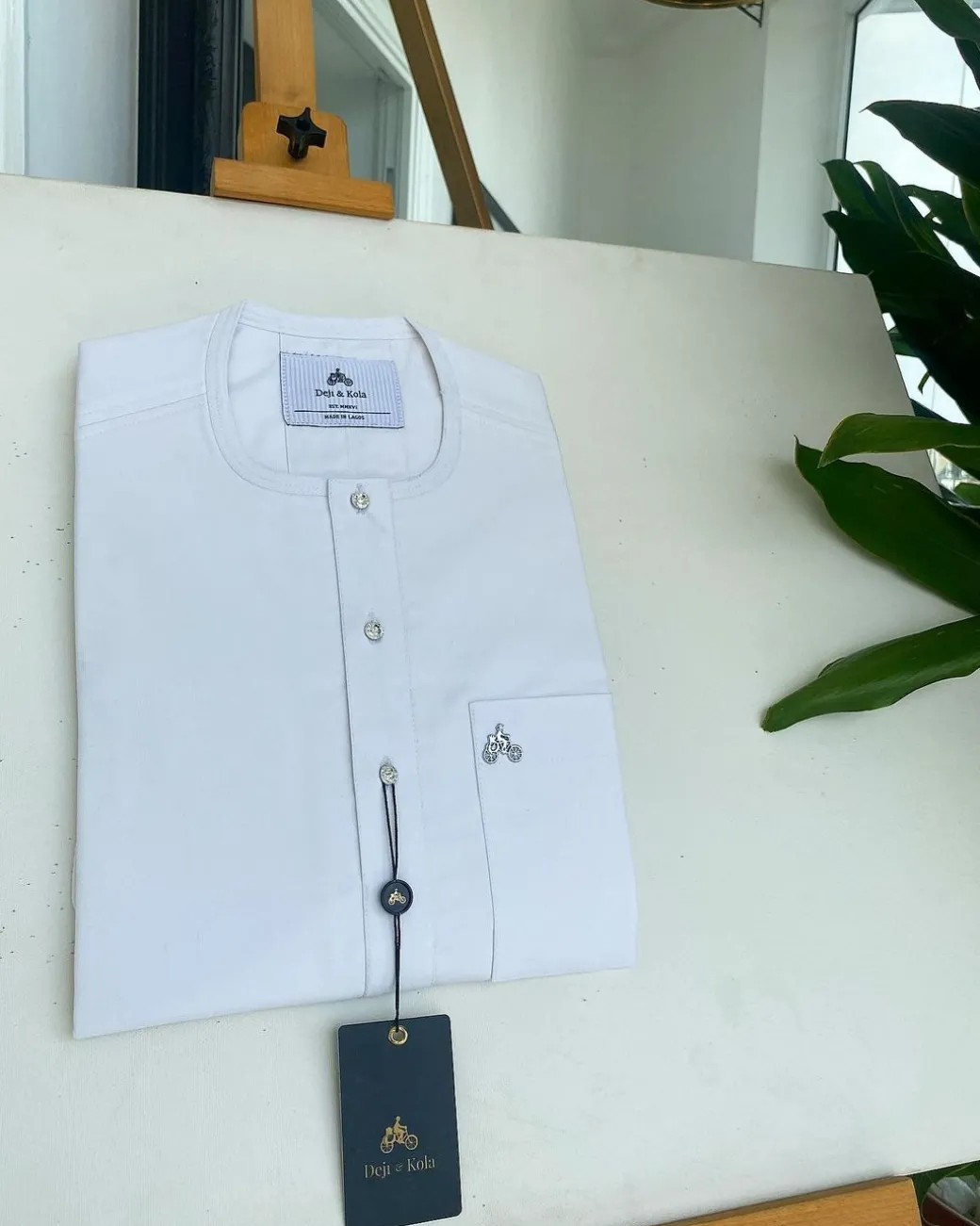 A white, clear view, transparent Swarovski buttons, front flap, and patch pocket detail African traditional senator Kaftan native.