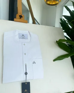 A white, clear view, transparent Swarovski buttons, front flap, and patch pocket detail African traditional senator Kaftan native.