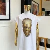 A white “daftan” with the Benin royalty prints and black Fulani hat