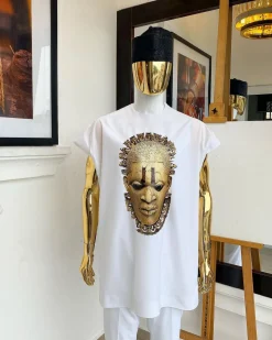 A white “daftan” with the Benin royalty prints and black Fulani hat