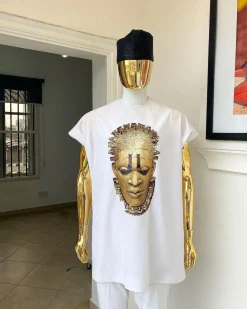 A white “daftan” with the Benin royalty prints and black Fulani hat