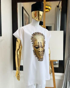 A white “daftan” with the Benin royalty prints and black Fulani hat