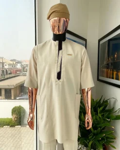 An Almond cream, lane, intersection flap, side patch pocket detailing african traditional senator kaftan native.