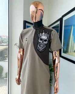 An almond ivory and cedar brown, black and gold metallic Jacquard neck and crown skull embroidery punk biker patch detailing African traditional senator Kaftan native.