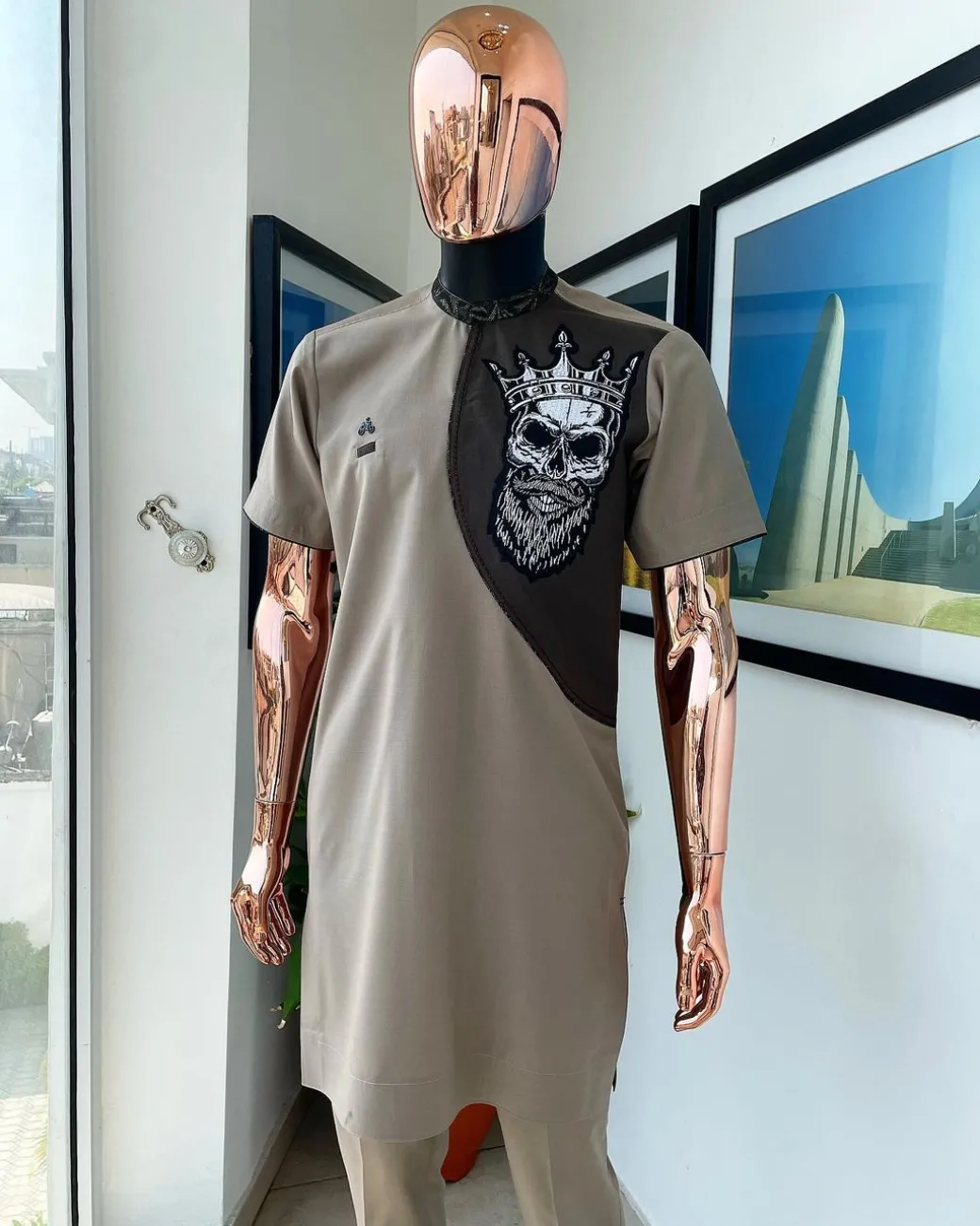 An almond ivory and cedar brown, black and gold metallic Jacquard neck and crown skull embroidery punk biker patch detailing African traditional senator Kaftan native.