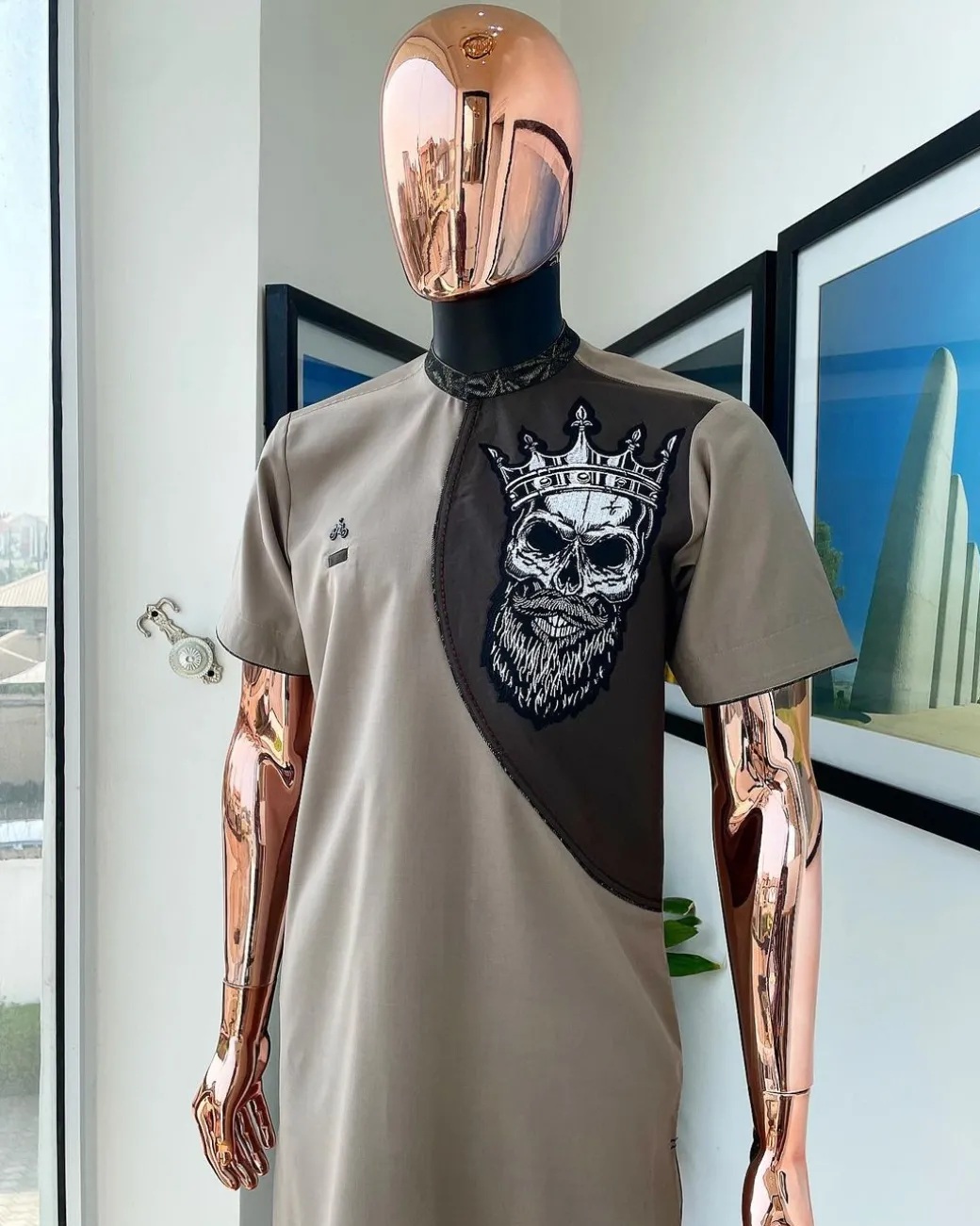 An almond ivory and cedar brown, black and gold metallic Jacquard neck and crown skull embroidery punk biker patch detailing African traditional senator Kaftan native.