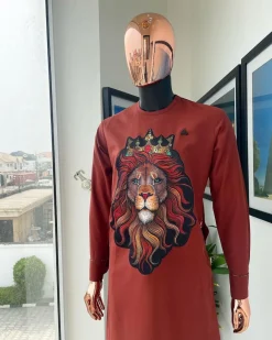 An Amber-orange piped neckline with a 3D lion king head patch stitched embroidery detailing African traditional senator kaftan native.