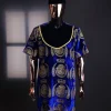 An “isiagu” gold, blue with matching fringe details, short sleeve, hat and velvet pant African traditional native.