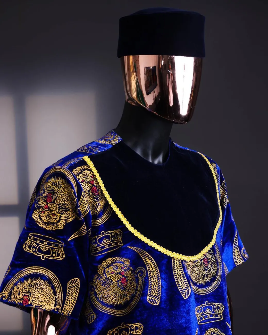 An “isiagu” gold, blue with matching fringe details, short sleeve, hat and velvet pant African traditional native.