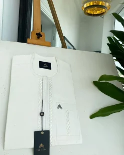 An ivory white, interwoven embroidery front flap and embroidery pocket detail African traditional senator kaftan native