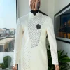 An ivory white, slide cut, navy blue dispersed safari suit with clustered Swarovski stone detailing