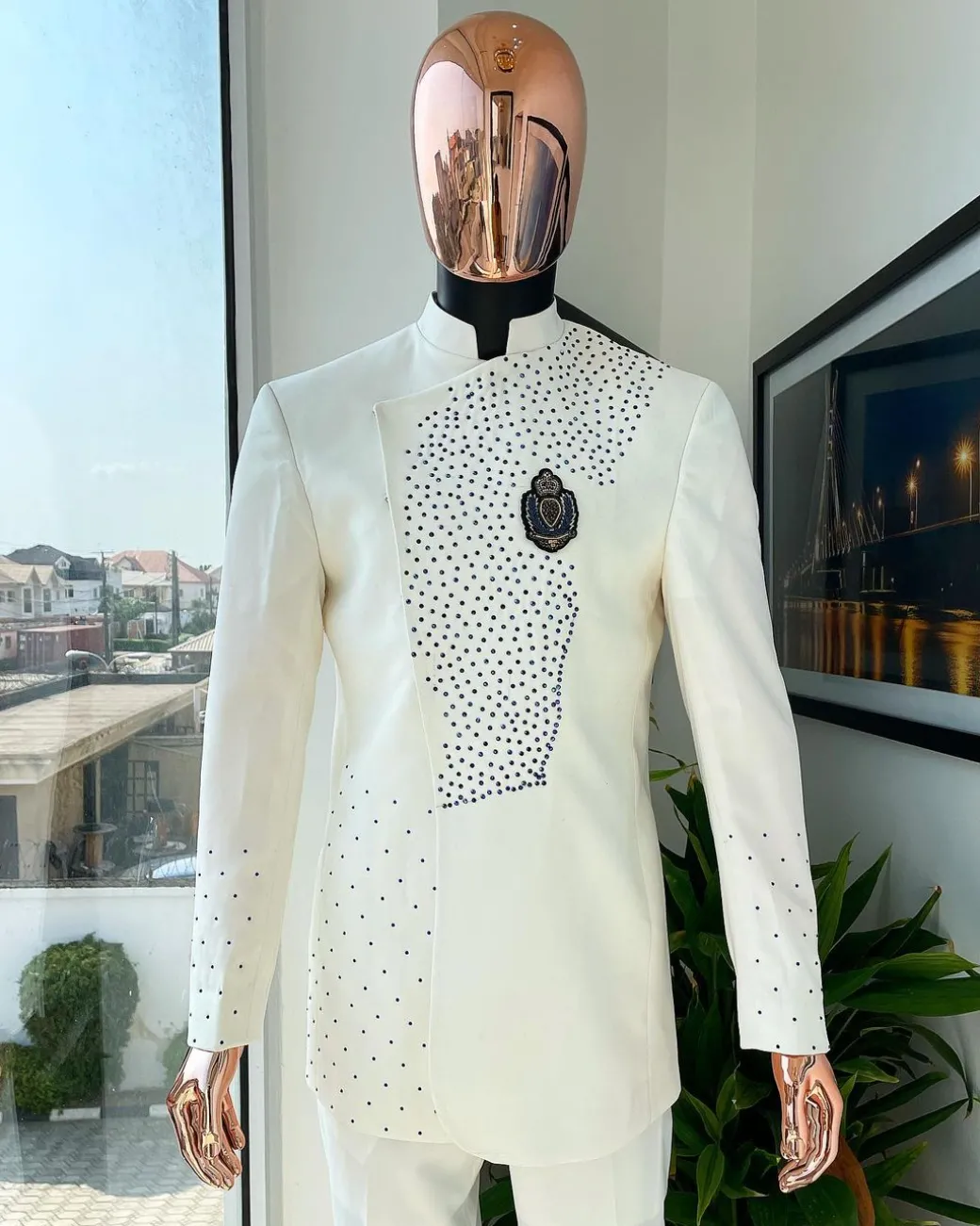 An ivory white, slide cut, navy blue dispersed safari suit with clustered Swarovski stone detailing
