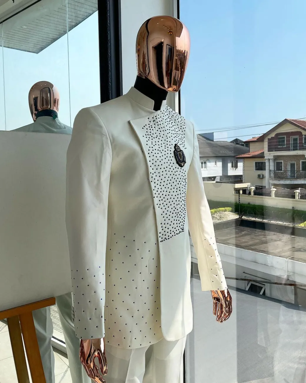 An ivory white, slide cut, navy blue dispersed safari suit with clustered Swarovski stone detailing