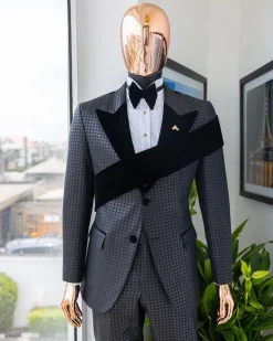 An “Octopus” black inverted square patterned jacquard tuxedo with left strap black velvet peak lapel suit