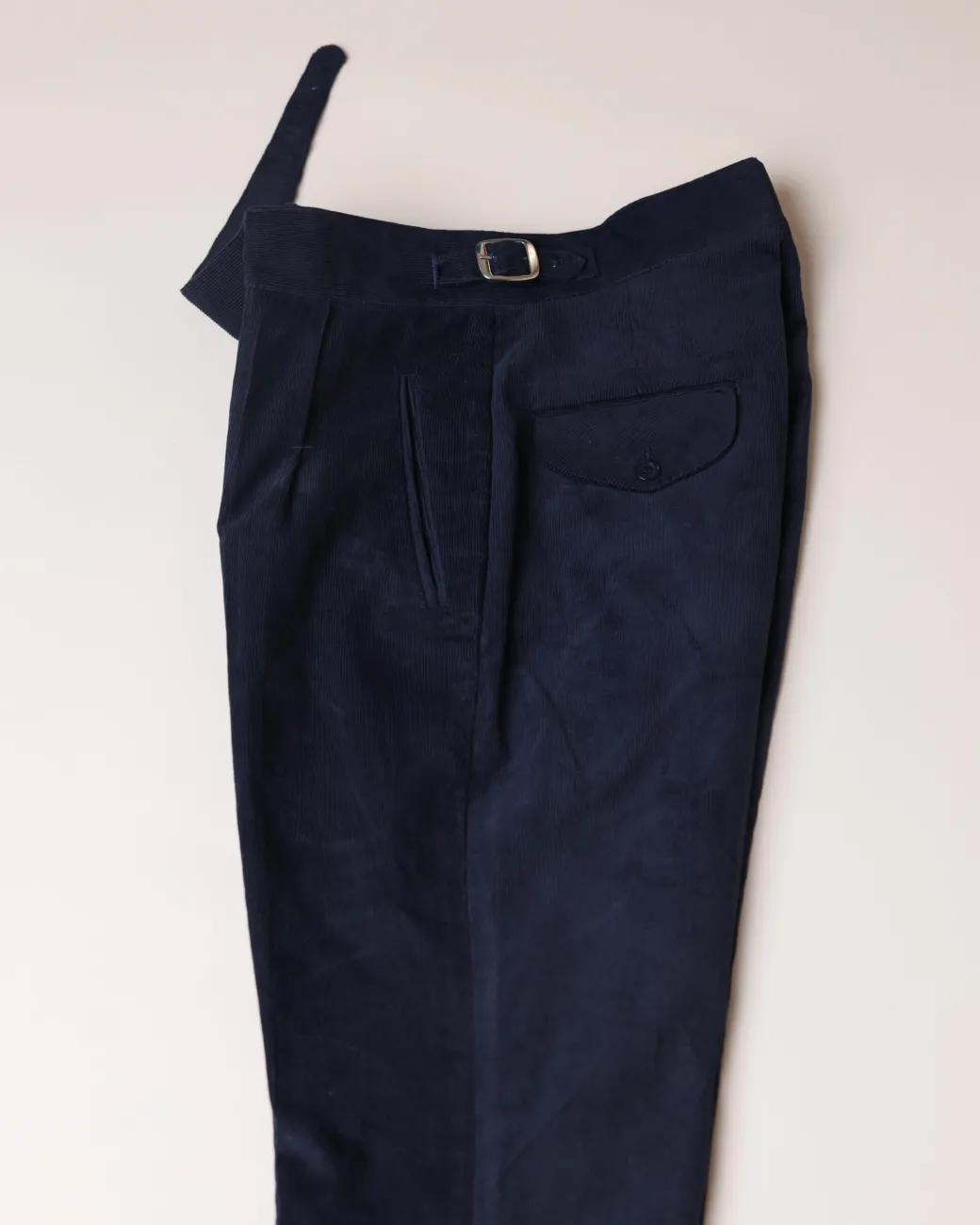 Gurkha trousers with pleats, double side strap buckles, slanted front welt pockets, and a back patch pocket.